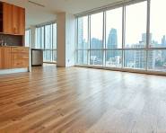 precision in flooring installation, skillfully laying down underlayment, seamlessly securing laminate boards, photorealistic, urban apartment with large windows showing cityscape, highly detailed, slight reflections on boards, wide-angle 24mm lens, natural earth tones, diffuse daylight illumination, shot with a wide-format camera